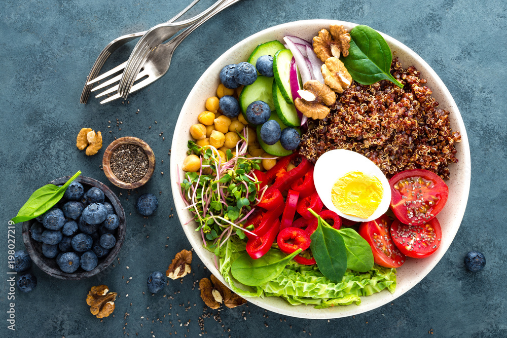 Buddha bowl dinner with boiled egg, chickpea, fresh tomato, sweet pepper, cucumber, savoy cabbage, red onion, green sprouts, spinach leaves, blueberry, walnuts, chia and quinoa Buddha bowl dinner with boiled egg, chickpea, fresh tomato, sweet pepper, cucumber, savoy cabbage, red onion, green sprouts, spinach leaves, blueberry, walnuts, chia and quinoa
