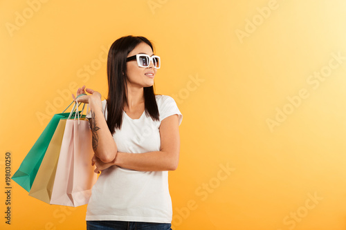 Portrait of a smiling young asian girl holding shopping bags