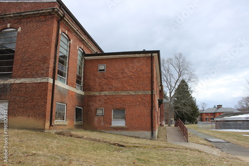 Old abandoned and boarded up brick asylum hospital building