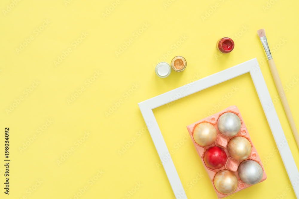 Flat lay top view colorful easter egg painted in pastel colors composition with paint brush on yellow pastel color background. Easter day background top view with copy space. Flat lay top view colorful easter egg painted in pastel colors composition with paint brush on yellow pastel color background. Easter day background top view with copy space.