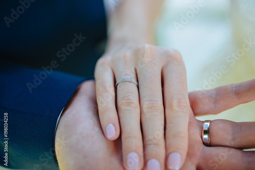 Lovers holding hands with gold wedding rings