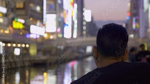 Tourist taking photos of neon lights in Osaka Japan photo