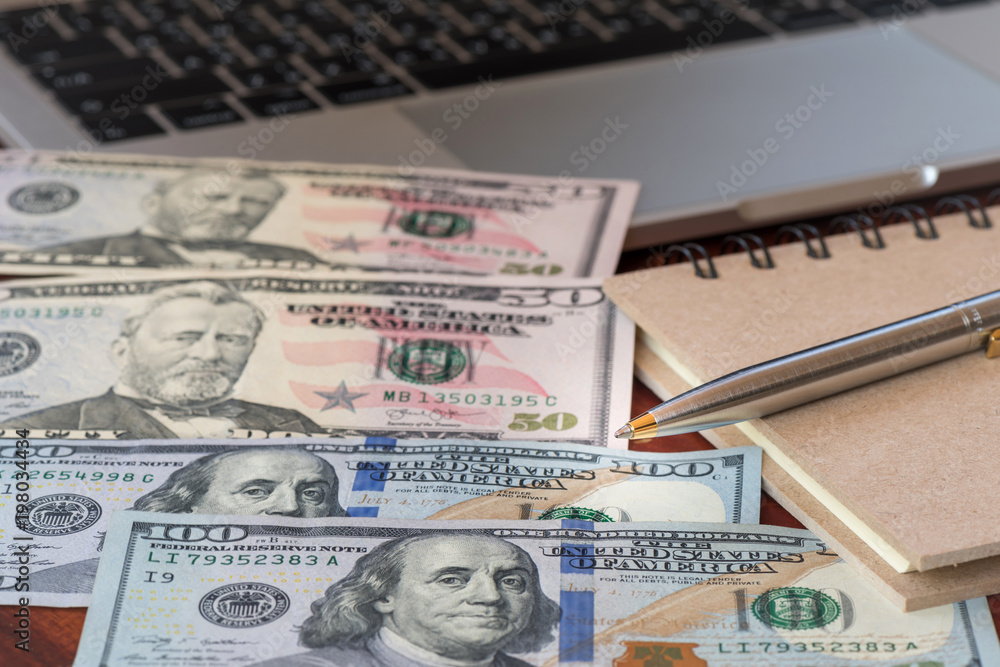 Closeup pen with US dollar banknote and keyboard in office Closeup pen with US dollar banknote and keyboard in office