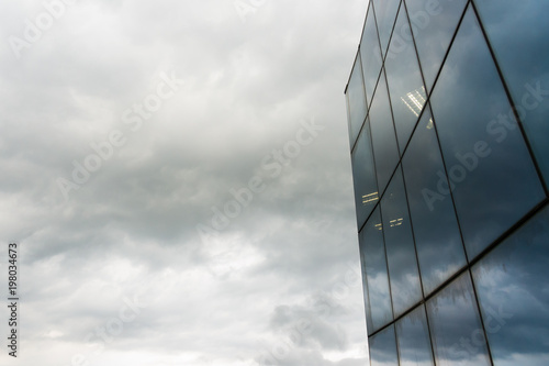 Modern glass silhouettes on modern building with gray sky