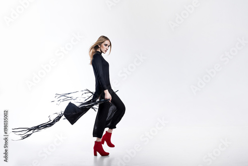 Fashion model on the white background in long modern clothers