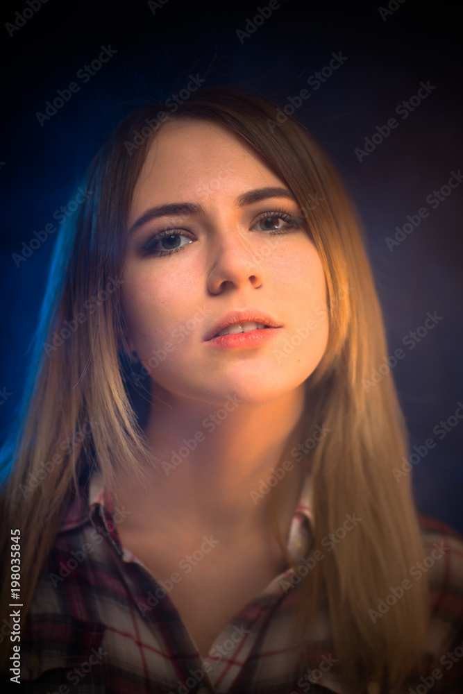 Fototapeta premium portrait smiling girl on blue background in studio