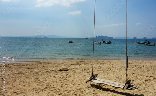 Summer, Travel, Vacation and Holiday concept - Swing hang from tree over beach sea in Khlong Muang Beach, Krabi,,Thailand.