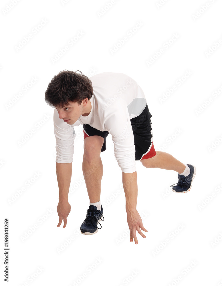 Young man in the start position for a run Young man in the start position for a run