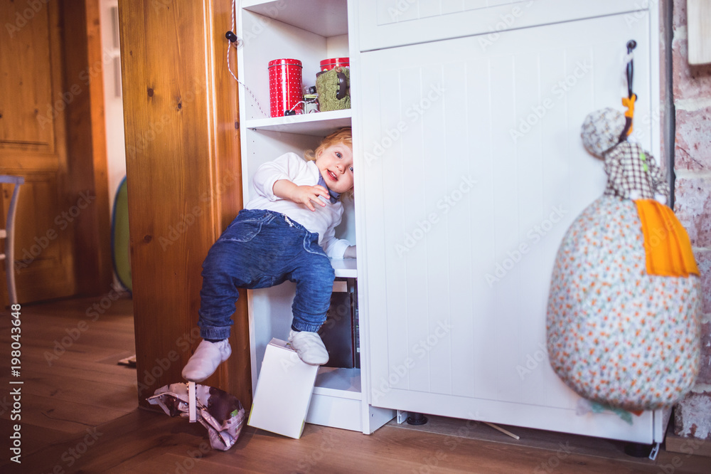 Toddler boy in dangerous situation at home. Child safety concept. Toddler boy in dangerous situation at home. Child safety concept.