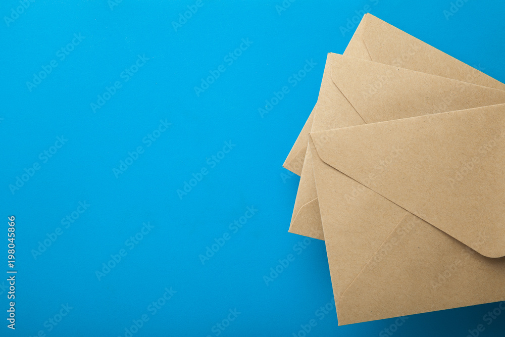 Three envelopes of recycled paper on a blue background, empty space for text. Three envelopes of recycled paper on a blue background, empty space for text.