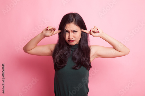 Young Asian woman block both ears with fingers. © halfbottle