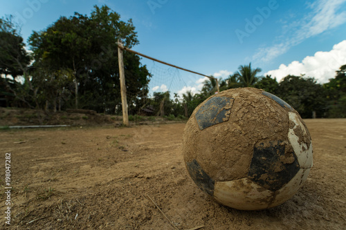 Fotografija close up old football on ground at a dirt pitch