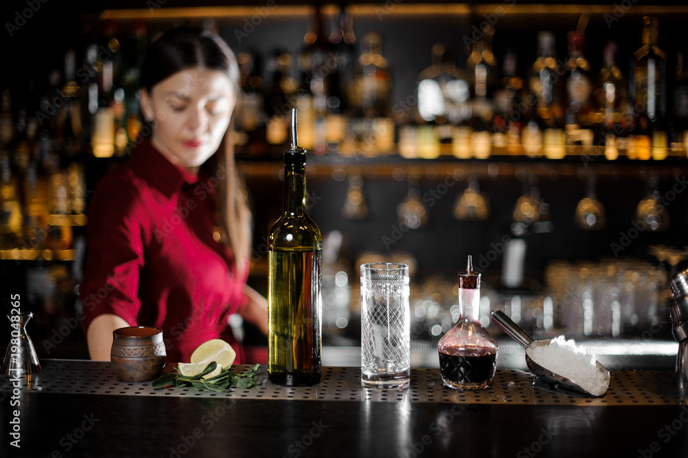 Glass, bottle and other barman essentials on the bar counter