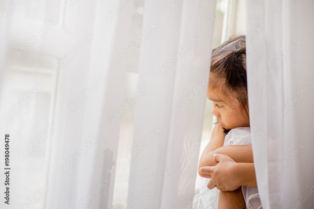 Pretty little girl looking through the window Pretty little girl looking through the window