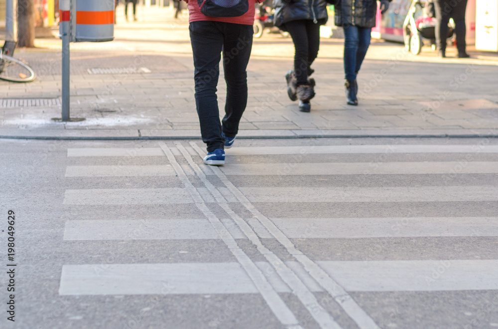 People crossing a zebra crossing in a street People crossing a zebra crossing in a street