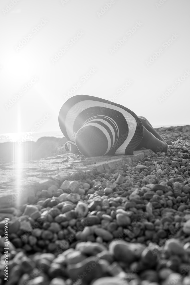 Woman sunbathing on a stony beach Woman sunbathing on a stony beach