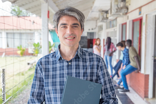 Teacher in the school hallway. Students in background photo