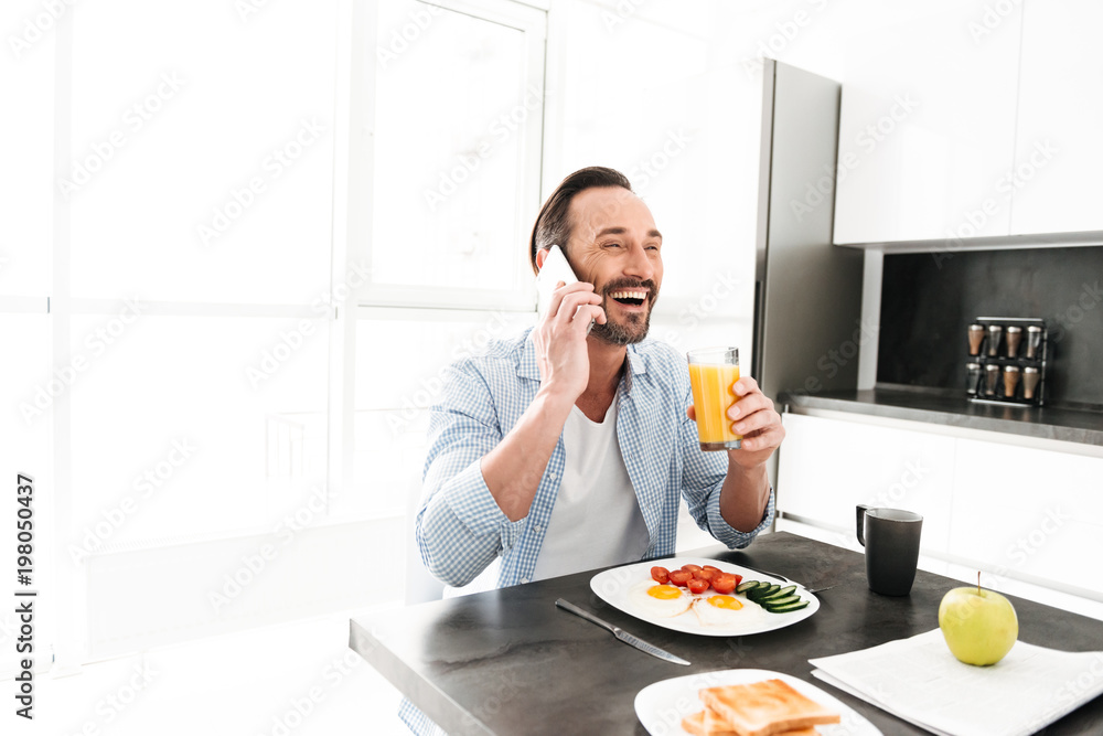 Laughing mature man talking on mobile phone Laughing mature man talking on mobile phone