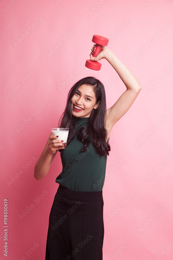 Healthy Asian woman drinking a glass of milk and dumbbell. Healthy Asian woman drinking a glass of milk and dumbbell.