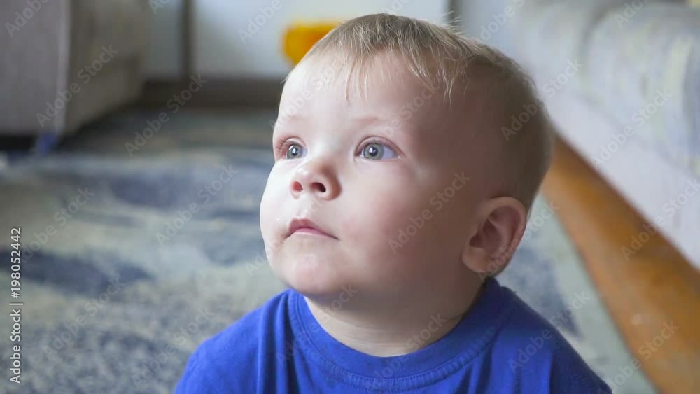 One year old child watching TV - dolly shot. Little boy watching cartoon on tv in the room. One year old child watching TV - dolly shot. Little boy watching cartoon on tv in the room.