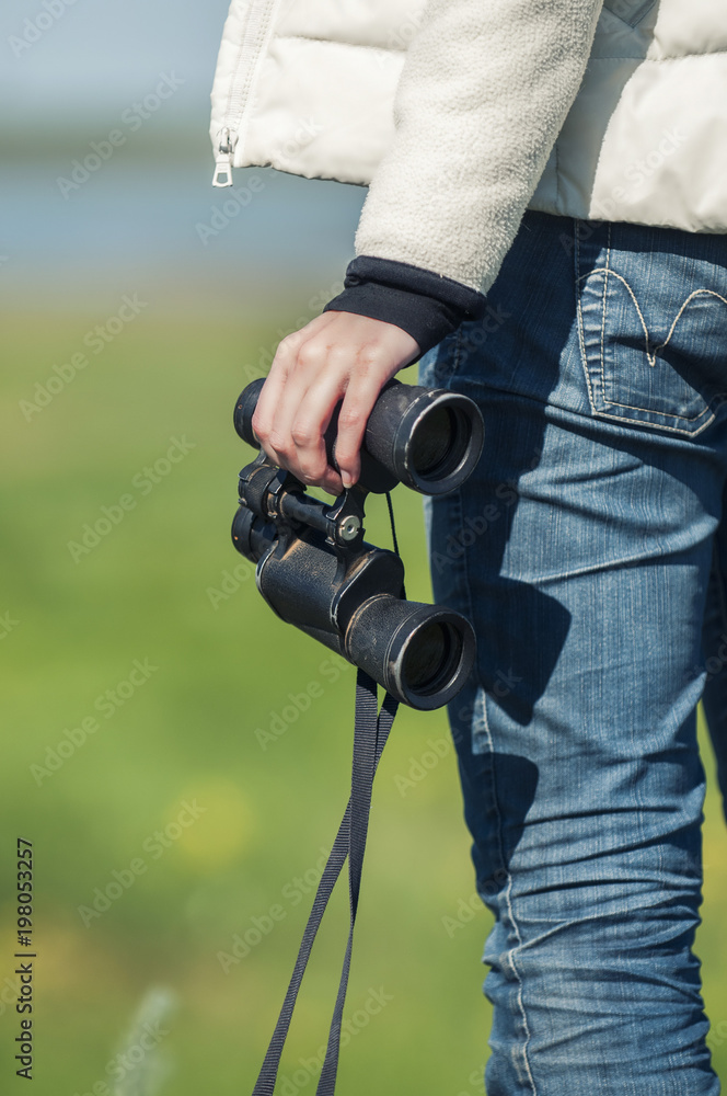 Woman with binoculars in the endless steppe.