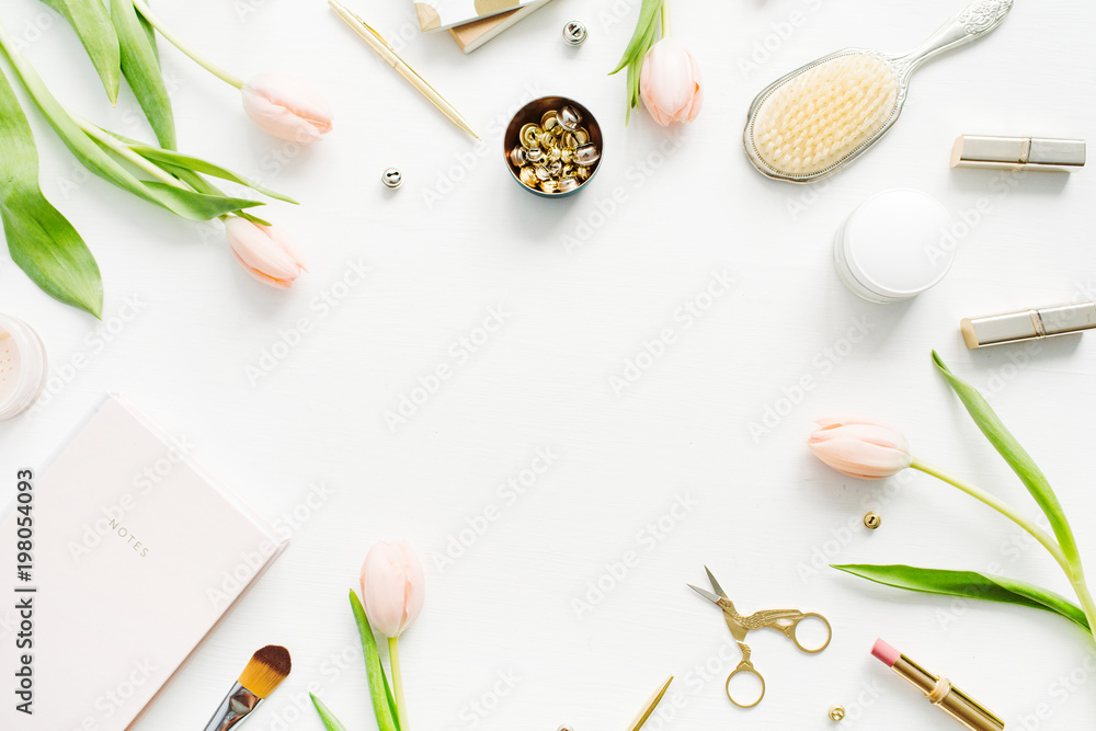 Frame of pink tulip flowers, accessories and cosmetics. Women home office desk mockup. Flat lay, top view hero header background.