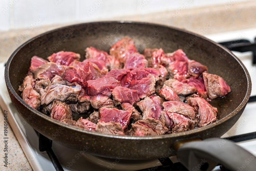 Pieces of beef cooking in frying pan Pieces of beef cooking in frying pan