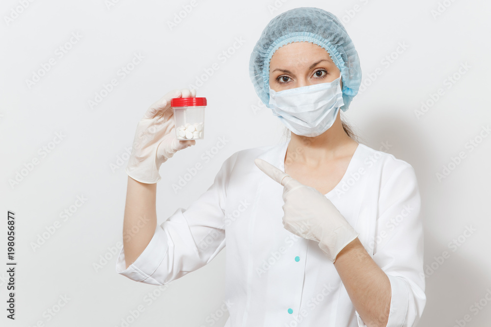 Young doctor woman with face mask, sterile hat, gloves isolated on white background. Female surgeon doctor in medical gown holding bottle with pills. Healthcare personnel, health, medicine concept. Young doctor woman with face mask, sterile hat, gloves isolated on white background. Female surgeon doctor in medical gown holding bottle with pills. Healthcare personnel, health, medicine concept.