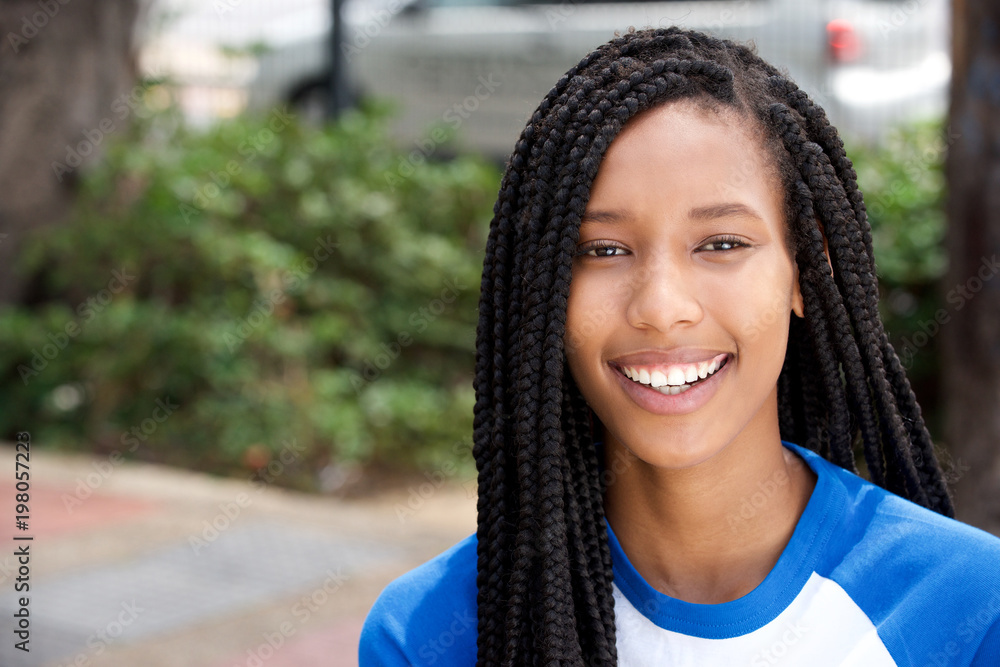 Naklejka premium horizontal portrait of smiling young african american woman outside