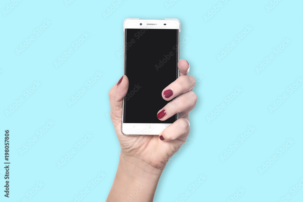 Left hand with red finger nails holds new modern smartphone with blank black screen - concept mobile communication young fresh lifestyle cellphone - isolated on blue background with copy space