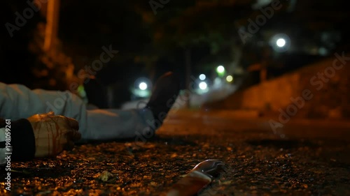 A VIOLENCE VICTIM ON THE GROUND AT NIGHT AND A KNIFE IS THROWN