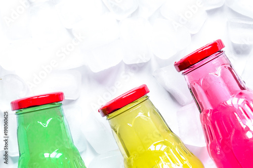 ice cubes and bright bottles on white background top view mock u