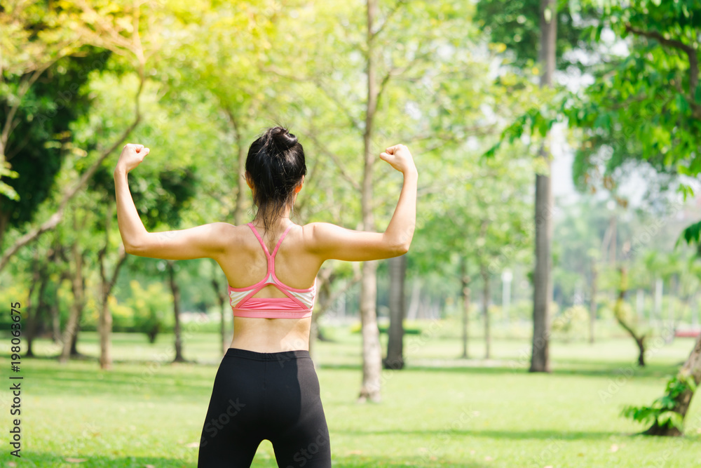 Asian woman stretching body in park, tan skin woman showing muscle body exercise using as sports and healthy concept Asian woman stretching body in park, tan skin woman showing muscle body exercise using as sports and healthy concept