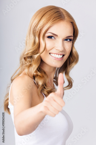 Wallpaper Mural Young woman with thumbs up gesture, over grey Torontodigital.ca