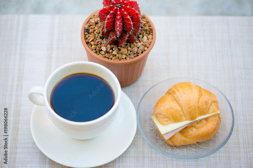 A cup of Black coffee with Ham and cheese croissant A cup of Black coffee with Ham and cheese croissant