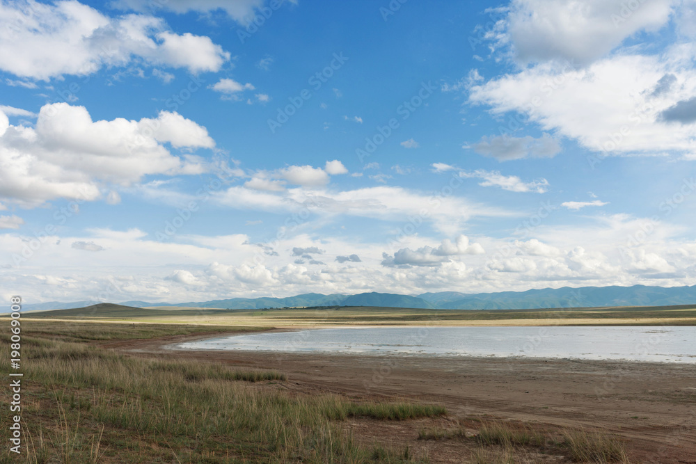 Clouds over the lake. Tyva. Steppe. Sunny summer day. Outdoors