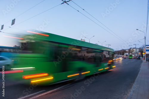 The motion of a blurred bus on the street at dusk