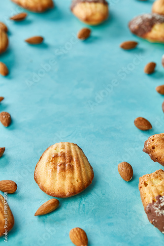 Yummy almond cookies arranged on blue background, close-up, selective focus, top view.