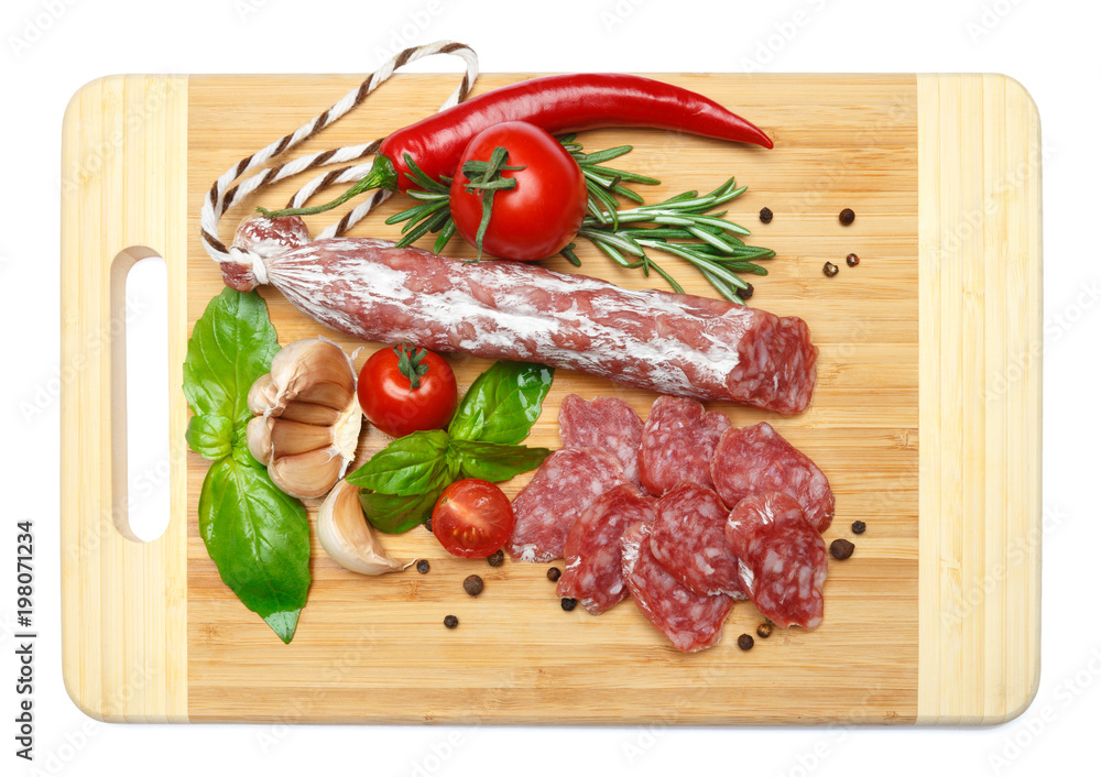 Dried sliced organic salami sausage on wooden cutting board