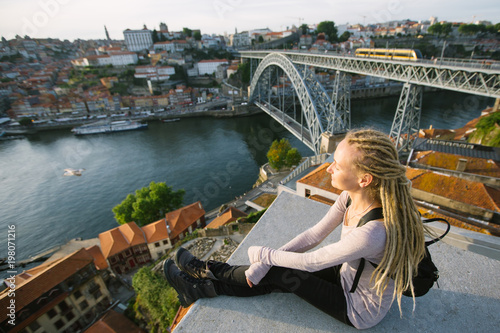 Young woman with blond dreadlocks on view point opposite the Dom Luis I bridge, Porto, Portugal. © De Visu