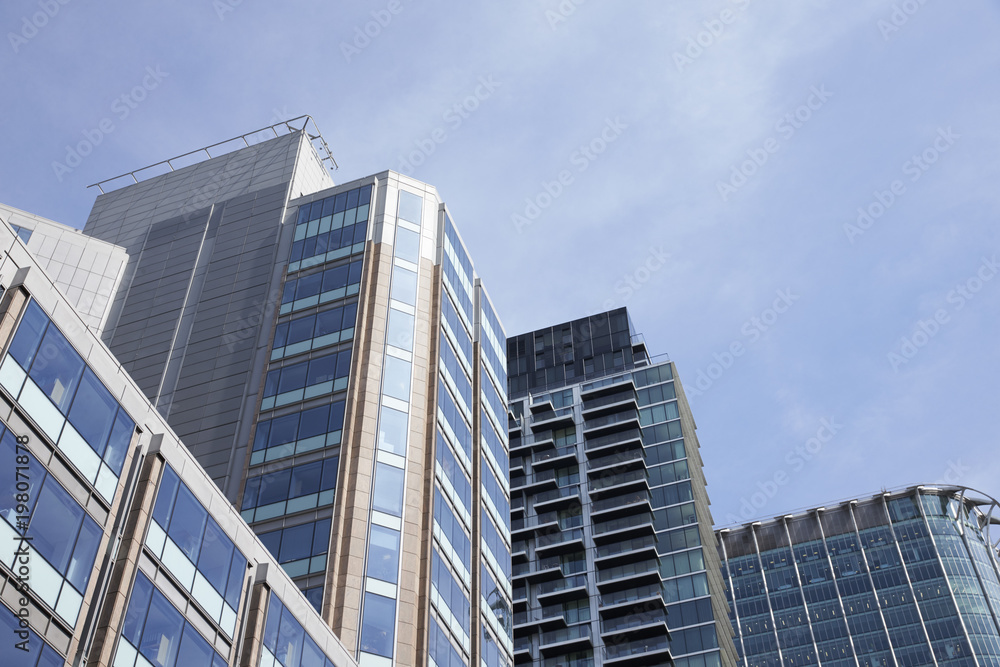 LONDON - MAY, 2017: Low angle view of modern glass fronted buildings against blue sky, City Of London, London LONDON - MAY, 2017: Low angle view of modern glass fronted buildings against blue sky, City Of London, London