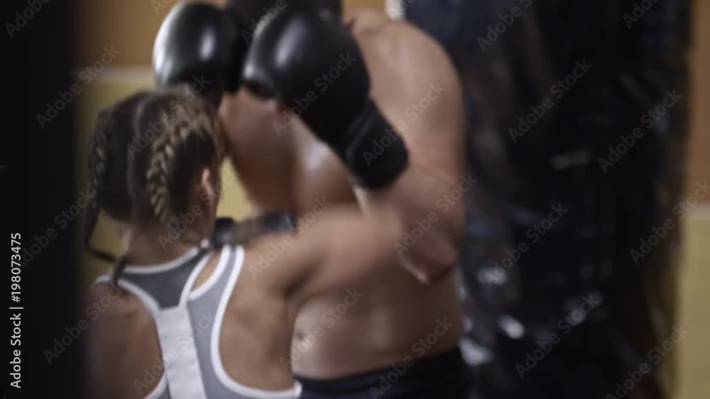 High angle view of man and woman in boxing gloves having boxing fight when doing workout at the gym High angle view of man and woman in boxing gloves having boxing fight when doing workout at the gym