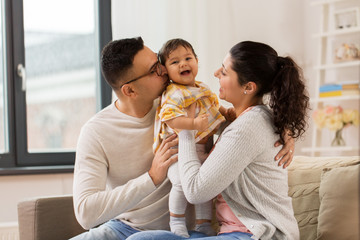 family, parenthood and people concept - happy mother, father with baby daughter at home