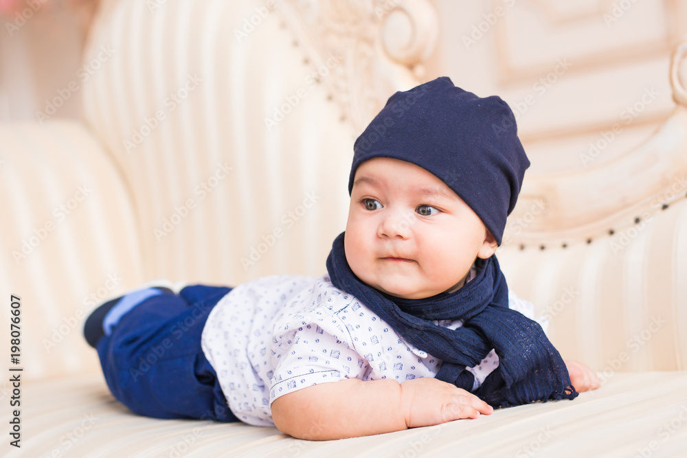 Baby boy lying on a sofa in sunny room Baby boy lying on a sofa in sunny room