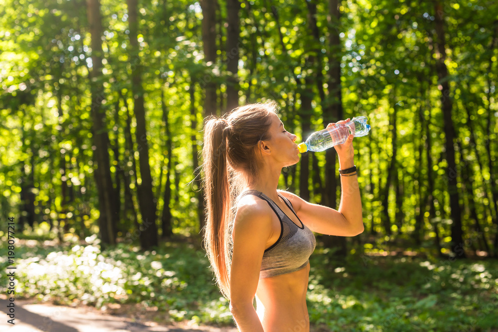 Sporty woman drinking water outdoor on sunny day. Sporty woman drinking water outdoor on sunny day.