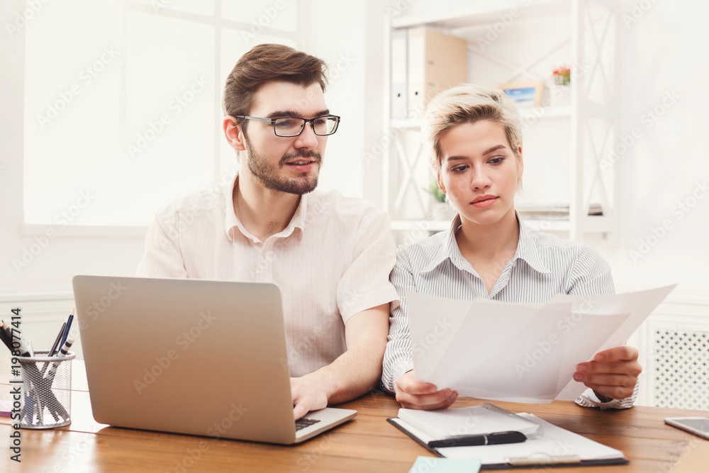 Couple of young colleagues working at modern office Couple of young colleagues working at modern office
