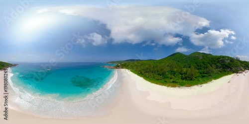 360VR 4K video aerial of tropical island sandy beach with turquoise lagoon and gentle waves on sunny vacation day from above with audio
