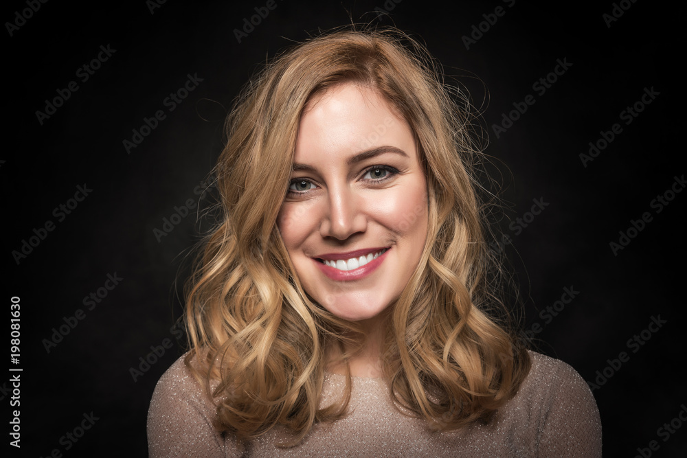 Portrait of an attractive young blonde woman on a black background. Portrait of an attractive young blonde woman on a black background.