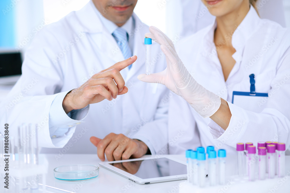 Team of scientific researchers in laboratory studying substances or blood sample. New vaccine for pharmacology industry is s almost ready. Medicine and science concept Team of scientific researchers in laboratory studying substances or blood sample. New vaccine for pharmacology industry is s almost ready. Medicine and science concept
