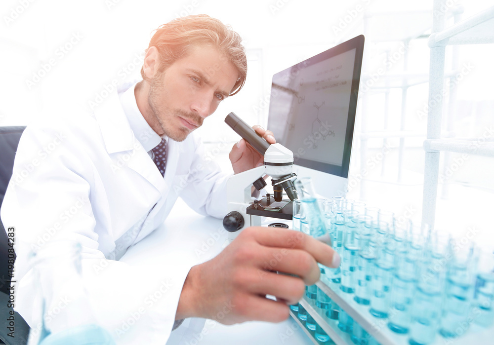 Chemist looking at test-tubes with blue liquids Chemist looking at test-tubes with blue liquids